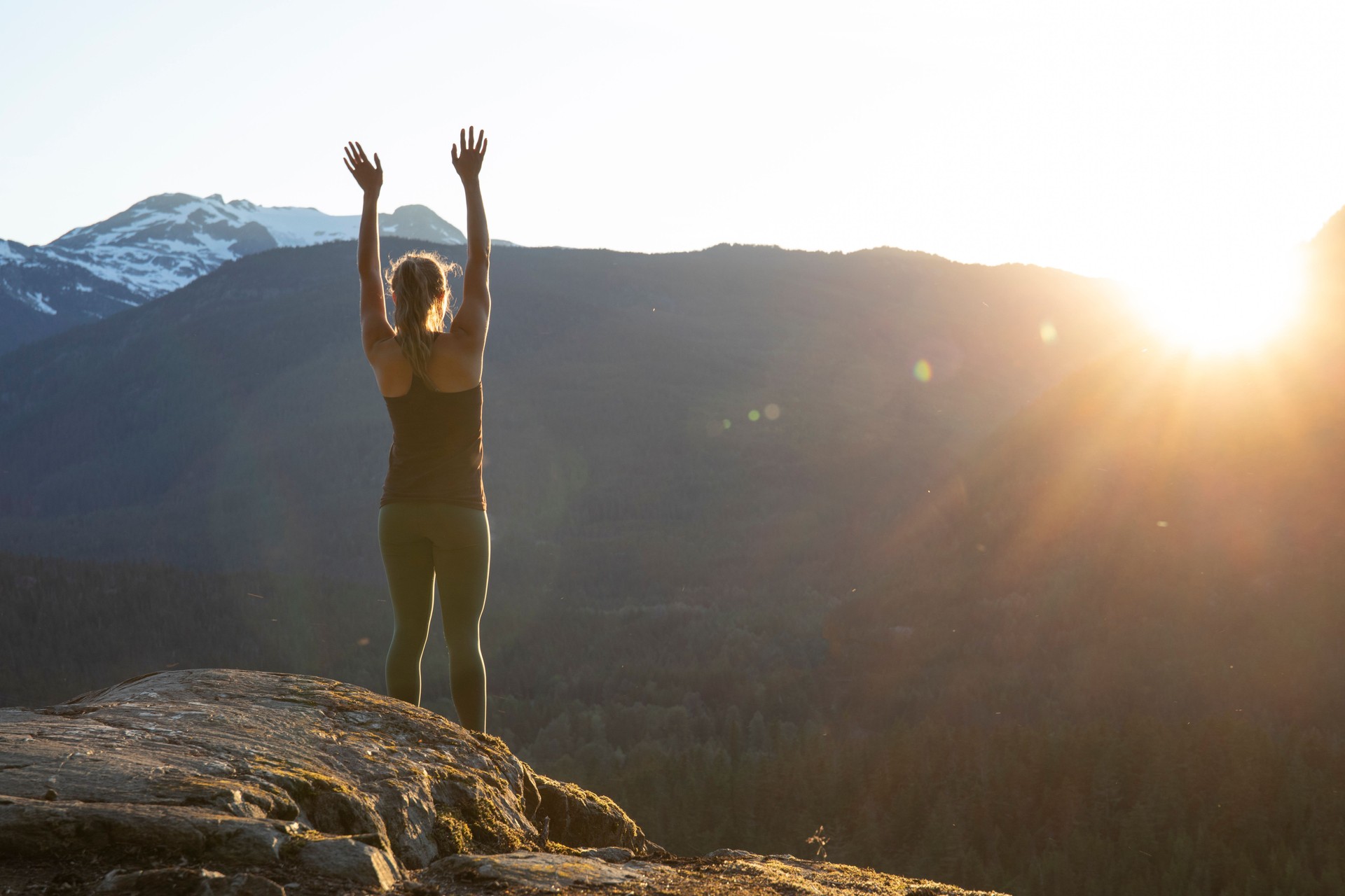 Young woman performs yoga moves on rock slabs